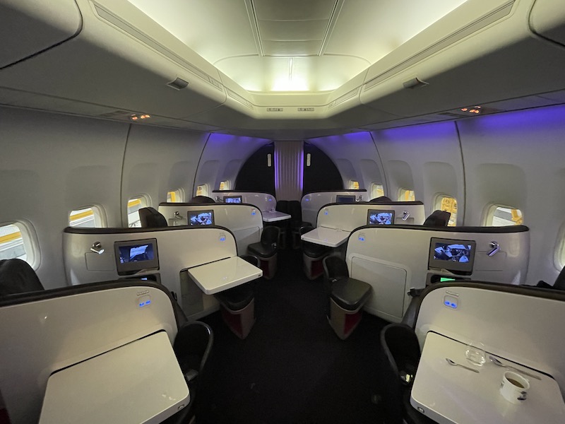 the inside of an airplane with seats and tables