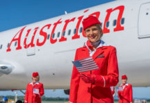 a group of women in red uniforms standing in front of a plane
