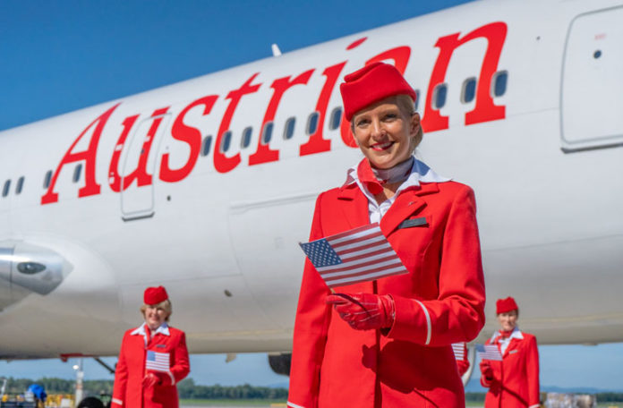 a group of women in red uniforms standing in front of a plane