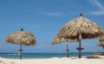 How to transfer Amex points to partner loyalty programs a group of straw umbrellas on a beach