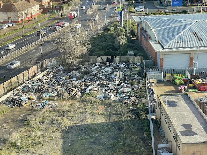 a pile of debris on the ground near a road