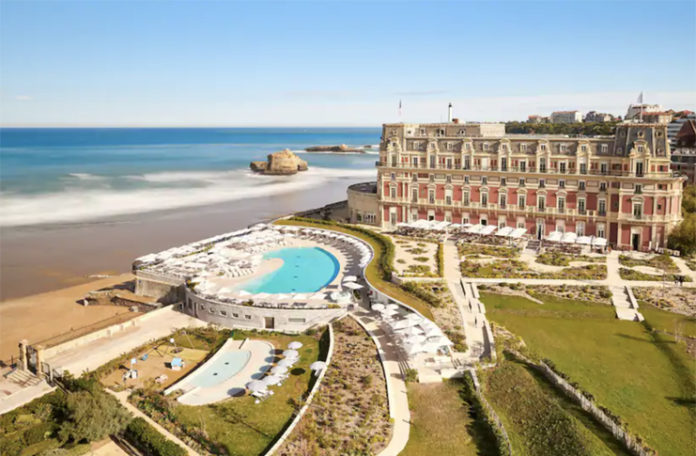 a large building with a pool and a beach