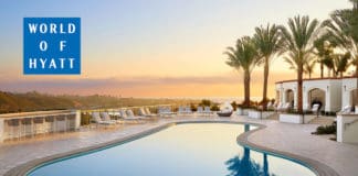 a pool with palm trees and a building in the background