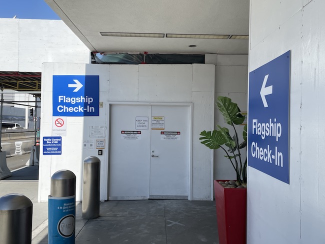 a white door with blue signs and a planter
