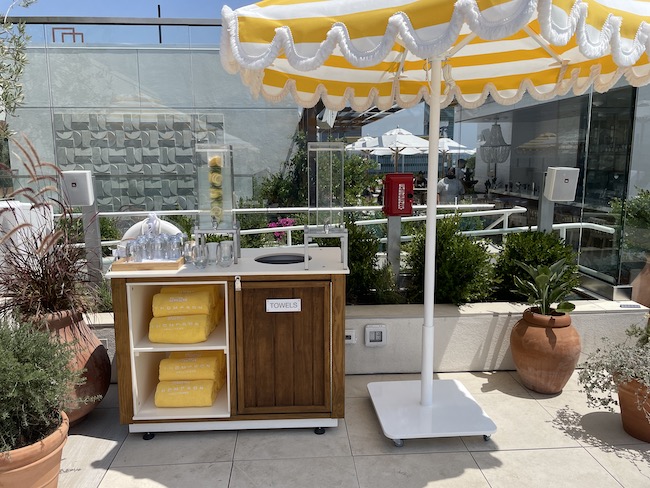 a yellow and white striped umbrella and a counter with towels