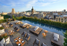 a rooftop bar with a pool and tables and chairs