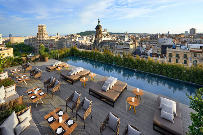 a rooftop bar with a pool and tables and chairs
