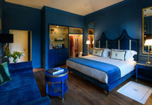 a bedroom with a blue wall and a bed