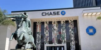 a statue of a man riding a horse in front of a bank