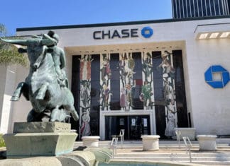 a statue of a man riding a horse in front of a bank