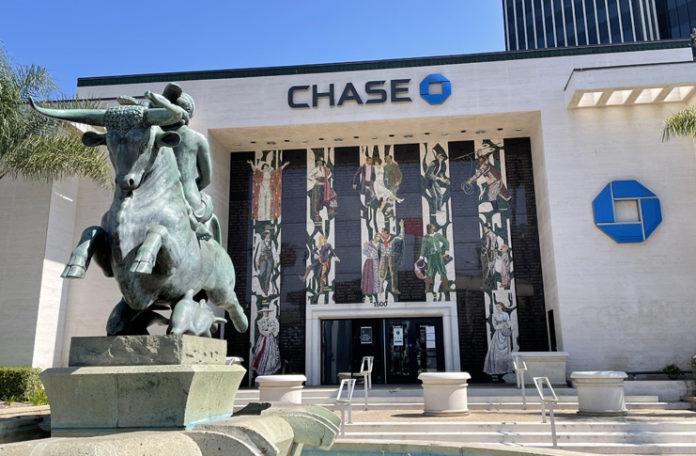 a statue of a man riding a horse in front of a bank