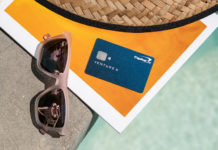 a credit card and sunglasses on a stone ledge