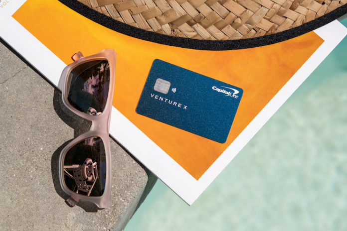 a credit card and sunglasses on a stone ledge