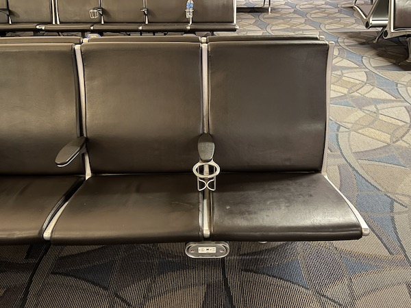 a row of black chairs in an airport