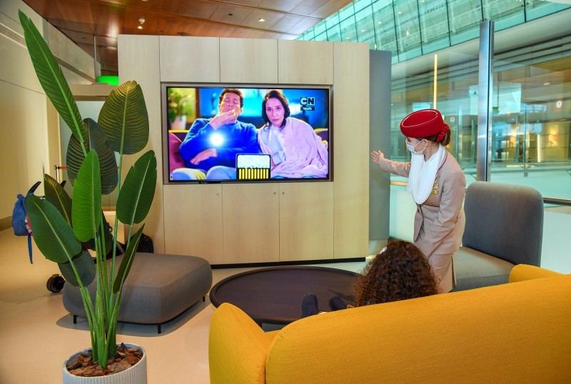 a woman in a red hat standing in front of a television