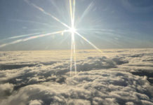 the sun shining over clouds