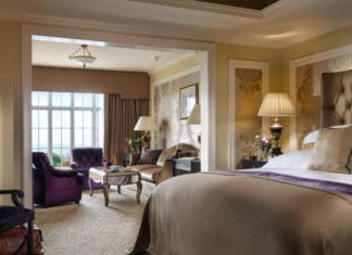 a room with a bed and chairs