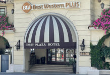 a hotel entrance with a striped awning