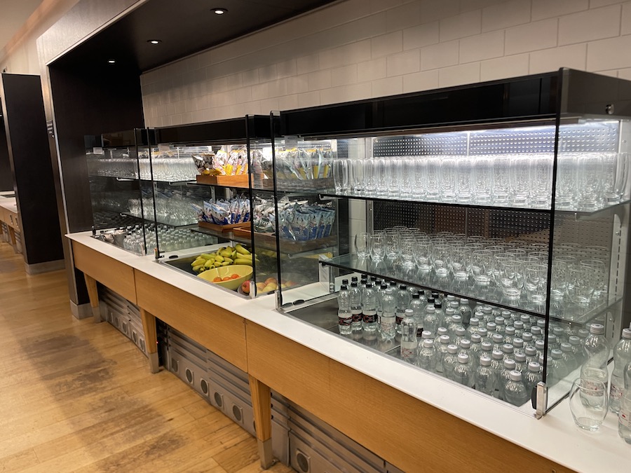 a display case with glass shelves filled with drinks and water