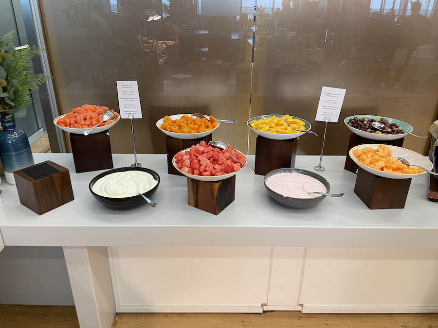 a table with bowls of fruit and yogurt