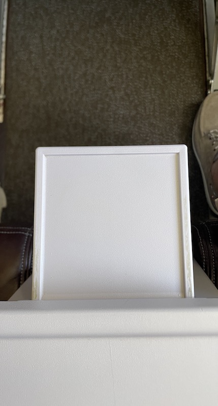 a white square frame on a shelf