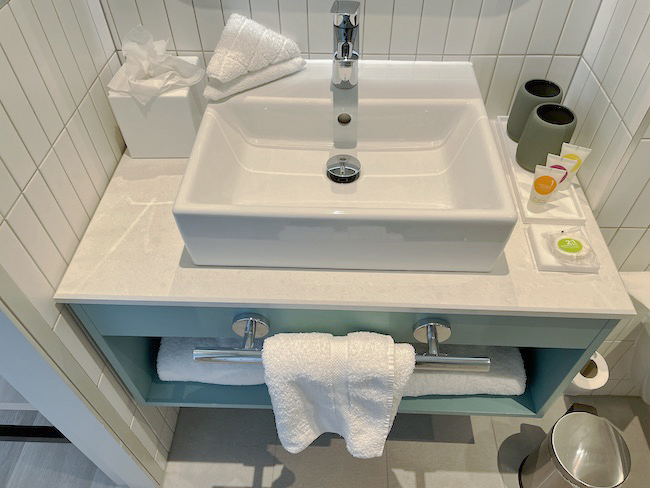 a bathroom sink with towels and a towel rack