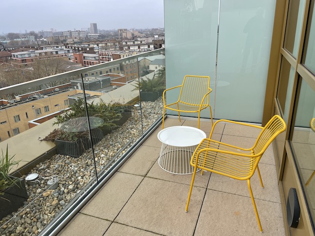 a yellow chairs and a table on a balcony