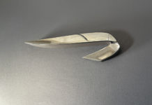 a silver knife on a gray surface