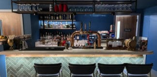 a bar with a row of chairs and a beer tap