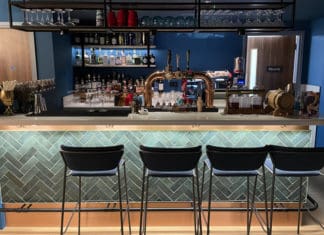 a bar with a row of chairs and a beer tap