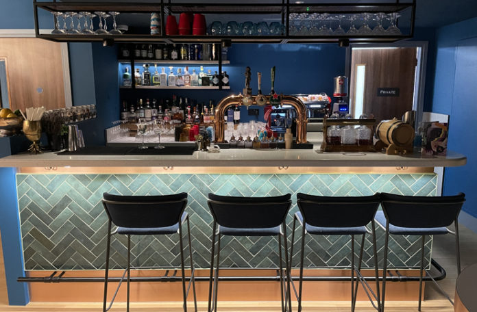 a bar with a row of chairs and a beer tap