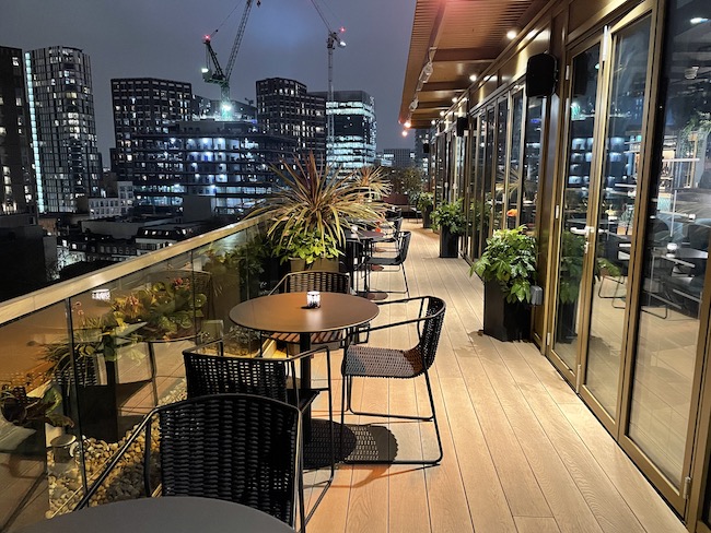 a rooftop patio with tables and chairs