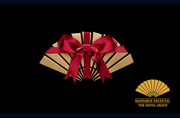 a gold fan with a red ribbon