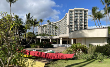 a building with a curved roof and a red canoe in front of it