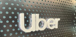 a white sign on a grey surface with holes