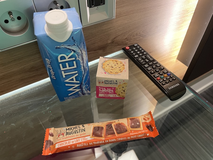a remote control and a box of water and a box of cookies