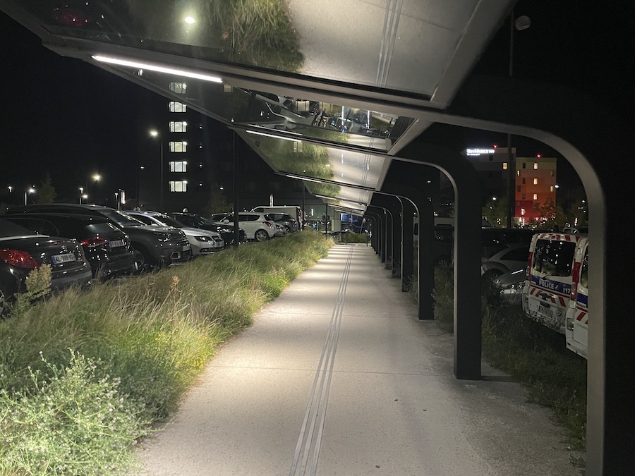 a walkway with cars parked in front of a building