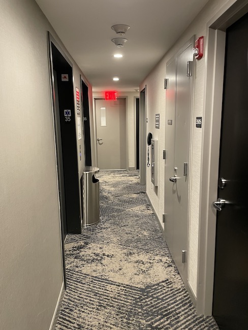 a hallway with doors and a red light