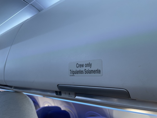 The overhead bin above seat 1A is reserved for crew use