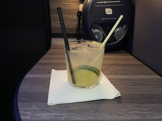 a glass with a drink and straws on a napkin