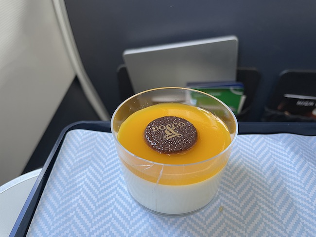 a cup of orange and white dessert