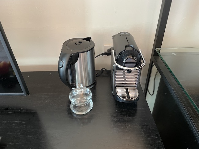a coffee maker and a glass on a table