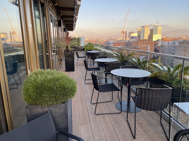 a patio with chairs and tables on a balcony