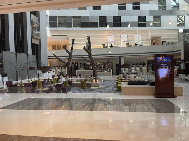 a large lobby with a tree and chairs