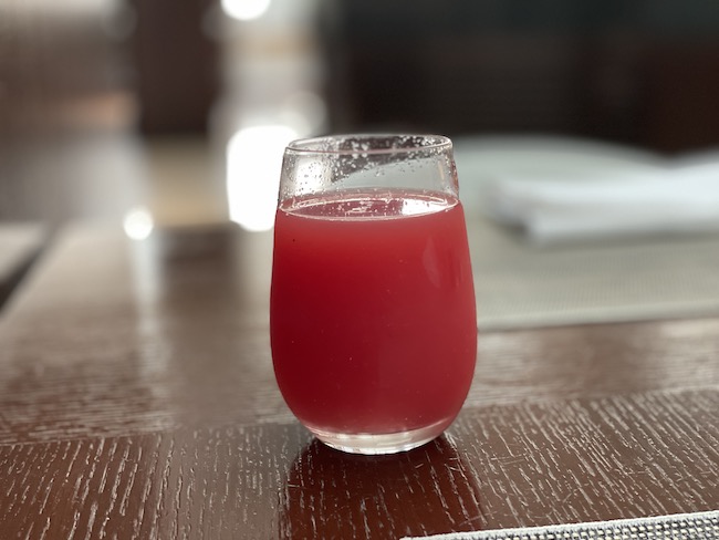 a glass of red liquid on a table