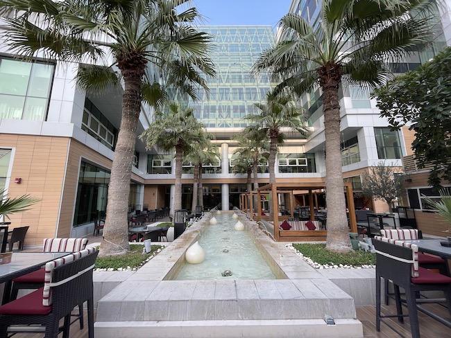 a building with palm trees and a fountain