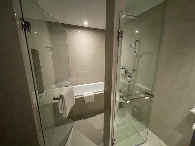 a bathroom with glass shower and bathtub