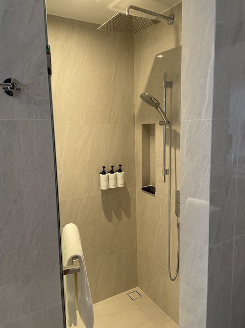 a shower with a towel and a rack