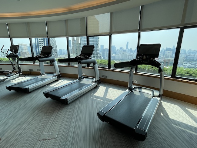 a group of treadmills in a room with a city view