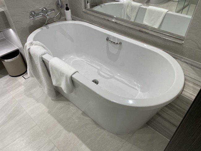 a bathtub with a towel on the side of it
